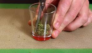 Cutting up Weed into a Shot Glass